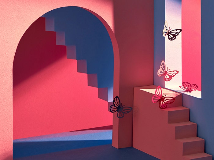 Interior shot of illustrated modern geometric style building in red, blue tones. Butterflies by staircase in doorway.